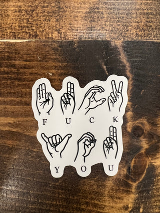Sticker with hand gestures on a wooden surface