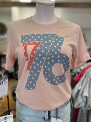 Pink t-shirt with '76' design on a mannequin in a store setting