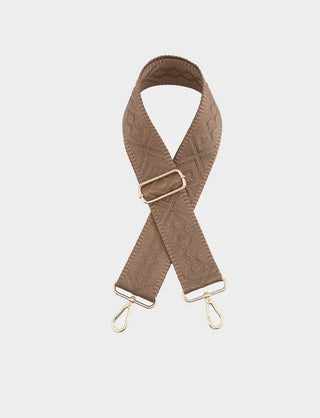 A brown woven fabric camera strap with an embossed geometric pattern and gold-tone metal hardware, including a buckle, rings, and snap hooks, displayed on a light gray background.