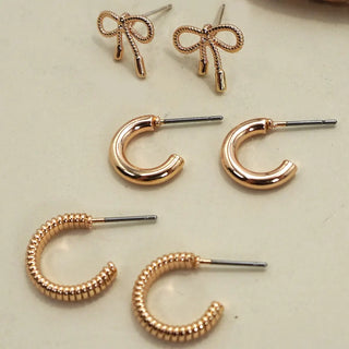 Set of gold hoop earrings on a light background