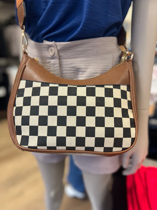 Checkered bag with brown leather trim worn by a person