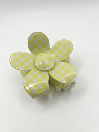 A glossy flower-shaped hair claw clip with a light yellow and white checkered pattern, shown on a plain white background.