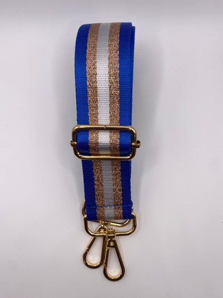 A blue nylon strap with a central silver stripe and a textured gold stripe, featuring a gold metal buckle and two gold swivel snap hooks at the bottom, shown on a plain white background.