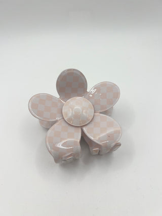 A glossy five-petal flower hair claw clip in a pale pink and beige checkerboard pattern, shown on a neutral light gray background.