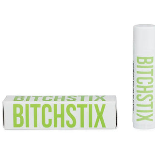 A white lip balm tube and its matching rectangular box, both printed with the brand name BITCHSTIX in bright lime green, on a plain white background.