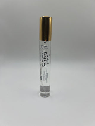 A small cylindrical tube of Room & Body Mist with a metallic gold cap and a white label, placed horizontally on a plain light gray background.