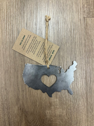 Metallic USA map with heart cutout on a wooden surface