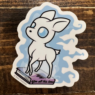 Sticker of a cartoon deer with blue eyes on a wooden surface