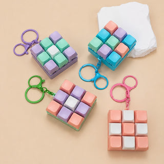 Colorful keychain cube with different colored keychains attached on a beige background