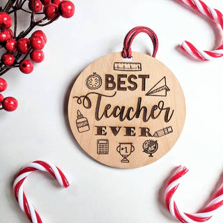 Wooden ornament with 'Best Teacher Ever' text surrounded by red berries and candy canes on a white background