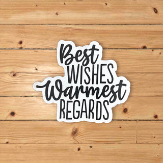 Sticker with 'Best Wishes Warmest Regards' text on a wooden background