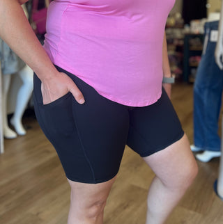 Person wearing a pink top and black shorts in a store setting
