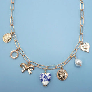 Gold necklace with various charms on a blue background