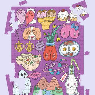 A completed jigsaw puzzle featuring a whimsical, cartoon-style collage of objects and characters on a purple background, including balloons, ice cream cones, a cat face, a pot with flowers, a bowl of ramen, a ghost, mountains, and a bottle, shown against a light lavender backdrop with a few loose puzzle pieces around the edges.