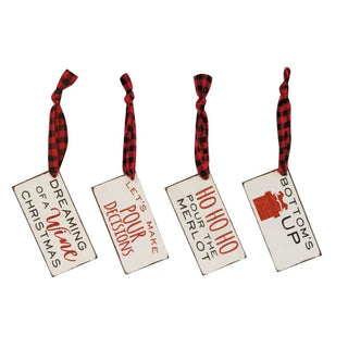 Four rectangular Christmas ornaments with a distressed cream finish, featuring red and black plaid hanging ribbons and holiday-themed printed phrases and graphics.