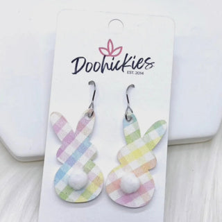 A pair of pastel plaid bunny-shaped dangle earrings with white pom-poms, displayed on a white card labeled 'Doohickies EST. 2014'.