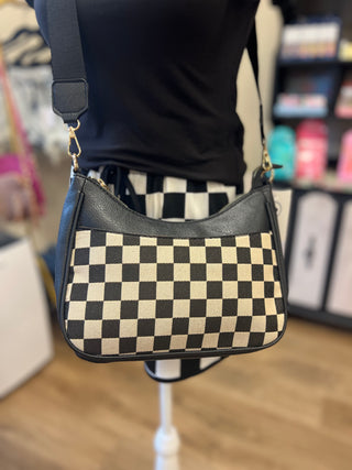 Black and white checkered bag on a mannequin in a store setting
