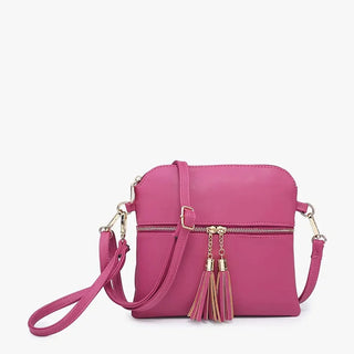 A bright pink faux-leather crossbody bag with a top zip closure, a front zip pocket, and decorative tassels with gold-tone hardware, shown on a plain white background.