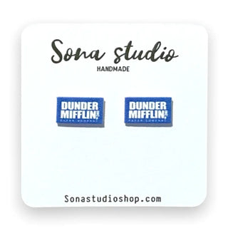 A pair of blue and white rectangular stud earrings with 'DUNDER MIFFLIN! OFFICE GEAR' text, displayed on a white card labeled 'Sona studio HANDMADE' with 'Sonastudioshop.com' at the bottom.
