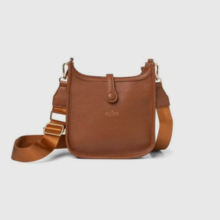 Brown leather handbag with a strap on a light gray background