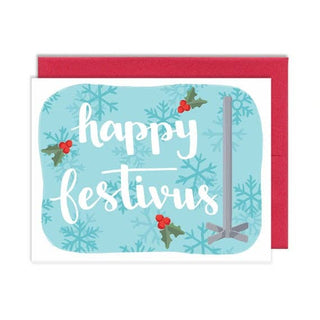 A festive greeting card with a red envelope, featuring the words 'happy festivus' in white script over a light blue background decorated with snowflakes, holly leaves, and red berries.