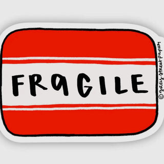 A die-cut sticker featuring a red and white striped design with the word 'FRAGILE' written in black across the center, shown on a light gray background.