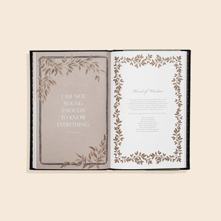 Open book with decorative pages on a beige background