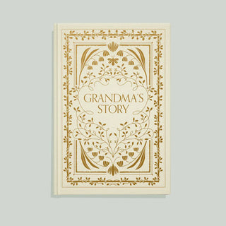 A hardcover book titled 'Grandma's Story' with an ornate gold botanical border and decorative title panel on a warm cream cover, shown against a light gray background.