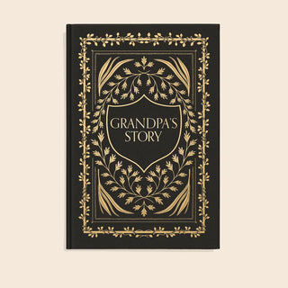A hardcover book titled 'Grandpa's Story' with a black cover and ornate gold foil detailing, centered on a light beige background.