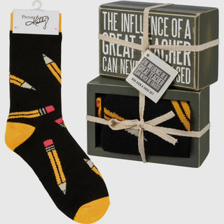 Black socks with yellow and pink accents and a decorative box with text.