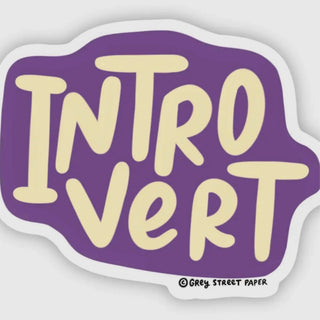 A die-cut sticker with a purple background and cream-colored bubbly text reading 'INTROVERT'. A small copyright mark at the bottom reads 'Grey Street Paper'.