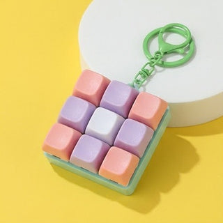 Colorful square keychain with a green base on a yellow background