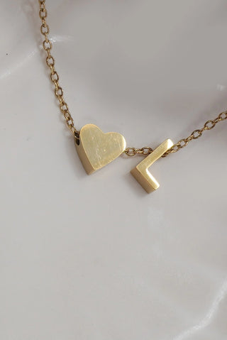 Gold necklace with heart and number 1 pendant on a white dish