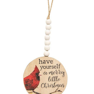 A round wooden Christmas ornament with a hanging string and white beads, featuring a red cardinal and the text 'have yourself a merry little Christmas' on a white background.