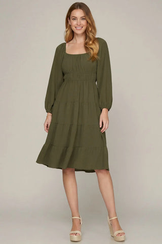 Woman wearing a green dress against a plain background