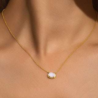 Gold necklace with a pendant on a person's neck