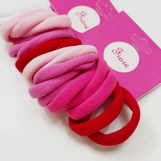 Pink and red hair ties with a pink packaging box in the background