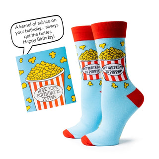 Light blue socks with red accents and popcorn design, paired with a birthday card, on a white background.