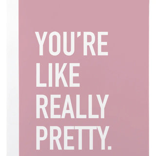 A square pink card or print with large white text reading “YOU’RE LIKE REALLY PRETTY.” centered on a white background.