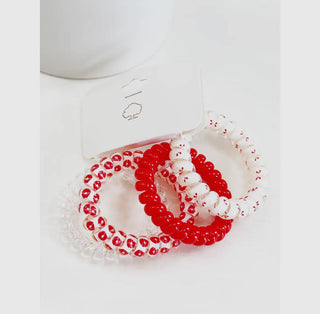 Set of red and white beaded bracelets on a white background