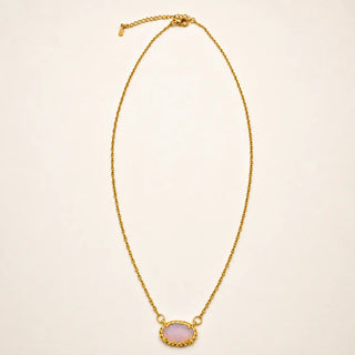 A delicate gold chain necklace featuring an oval pendant with a light pink stone and a textured gold border, displayed on a clean off-white background.