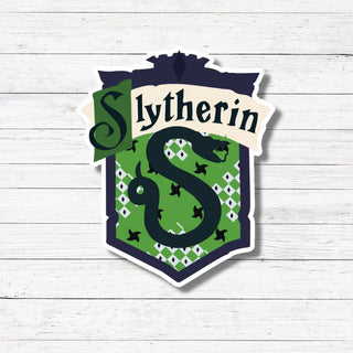Slytherin house emblem with green and navy design on a white wooden background