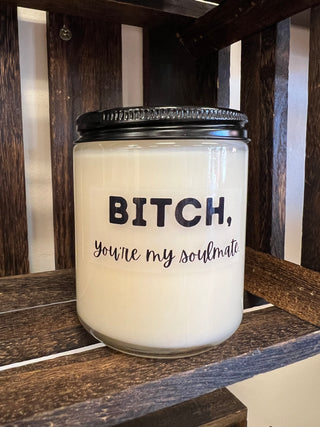 Candle jar with text on a wooden surface