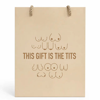A beige gift bag with rope handles and brown printed text and nipple illustrations reading 'THIS GIFT IS THE Tits' on a white background.