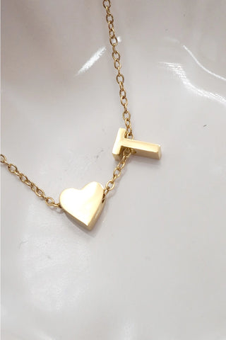 Gold necklace with a heart pendant on a white background