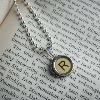 Necklace with a key-shaped pendant on an open book