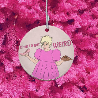 Decorative ornament with a cartoon character and text 'time to get WEIRD' on a pink Christmas tree.