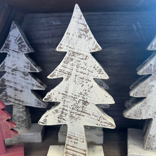 Wooden Christmas tree decorations with a distressed finish on a dark background
