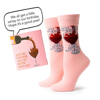 Pink socks with wine-themed designs and a matching card on a white background